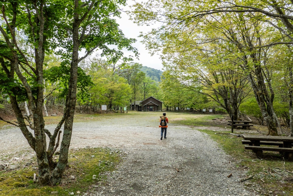 <p>山犬段の広場に出た。<br>奥に見えるのは山犬段休憩舎で、中はとても広く清潔にされていた。<br>数年前までは、ここまでマイカーで乗り入れることができたのだそう。現在は専用の相乗りタクシーを予約する必要がある。</p>