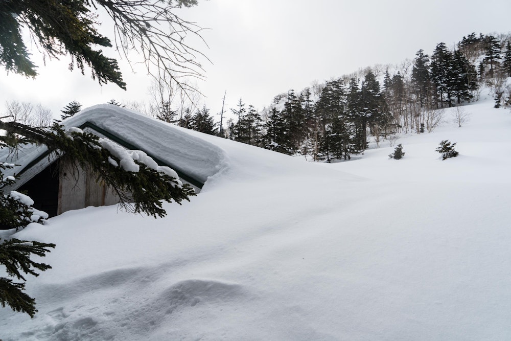 <p>想像以上に雪深く、しばらく誰にも登られていないようでトレースもない。<br>夏にはスイカを振る舞ってくれることで有名な合戦小屋も、これだけ雪に埋もれている。</p>