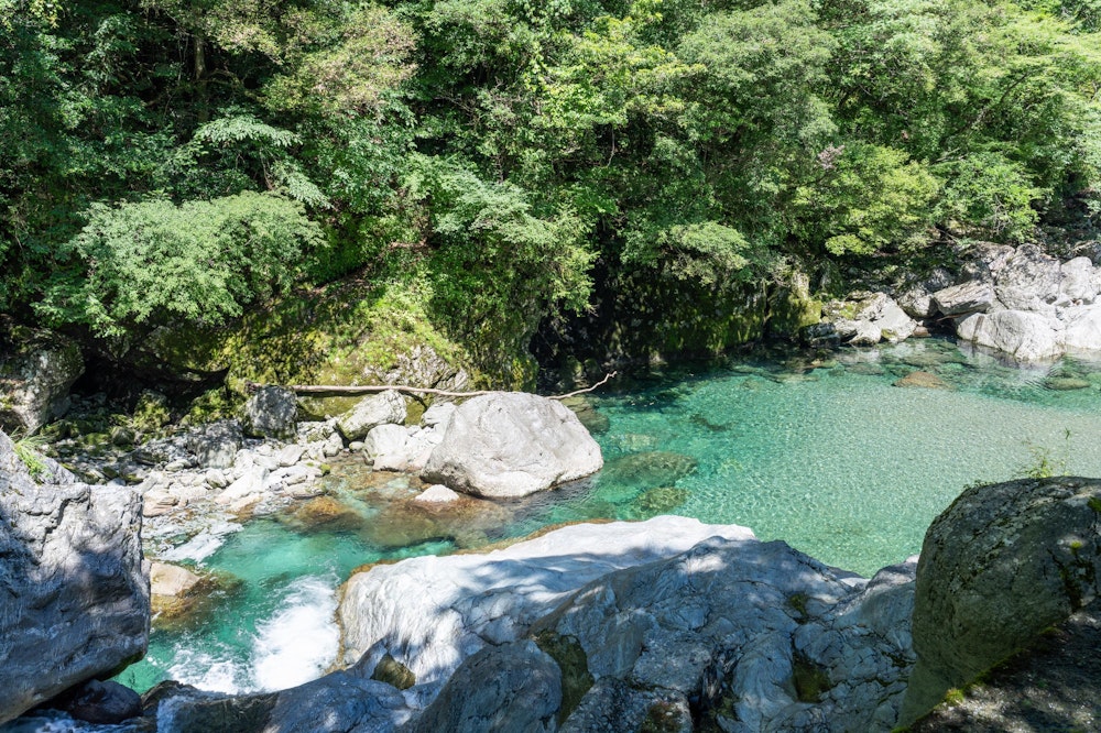 <p>安居渓谷の駐車場に車を停めて、水晶淵や砂防堰堤を目指す。<br>しばらく車道沿いを歩くが、川に目をやるとすでにこの美しさ。青く透き通っている。</p>