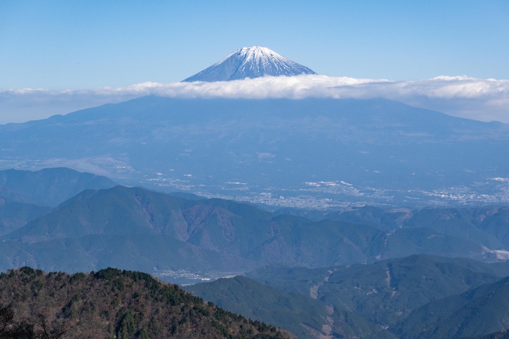 <p>水を汲んでいる間に、富士山には雲の帯がかかっていた。</p>