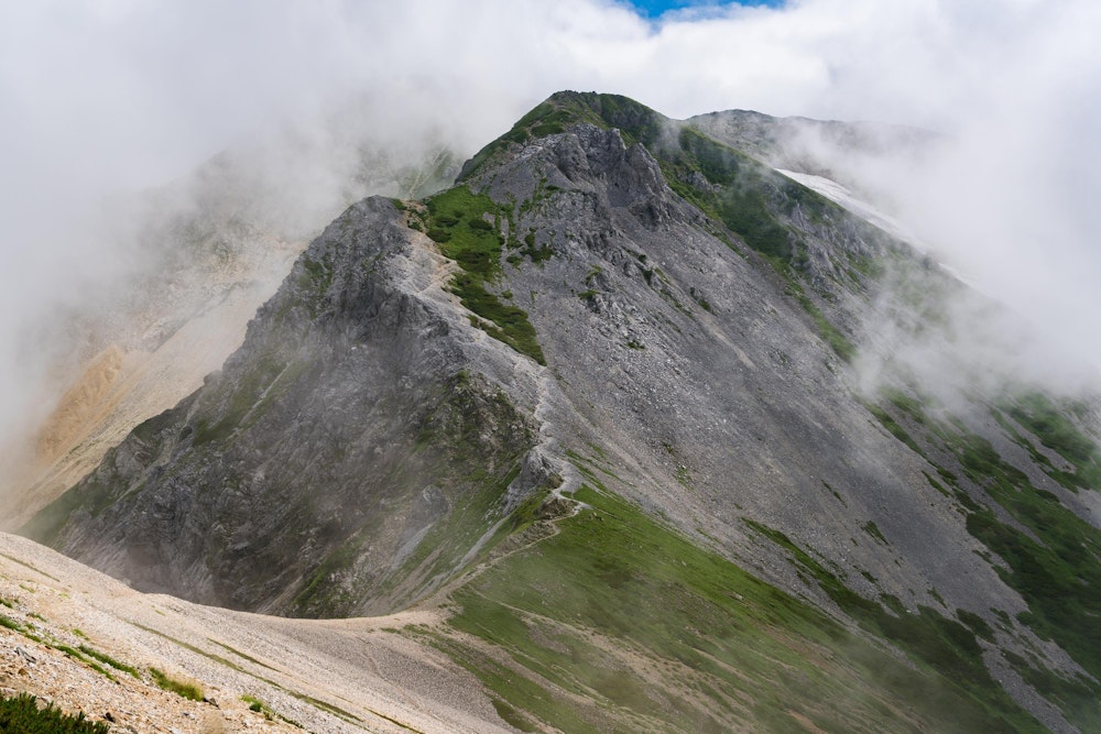 <p>二日目。冴えない天気の中、作業的に白馬岳に登頂し、杓子岳を越えて白馬鑓ヶ岳を目指していると、一瞬晴れた。</p>