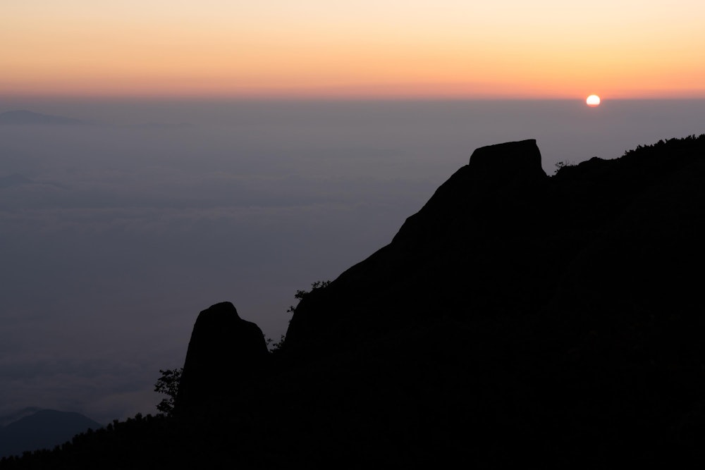 <p>翌朝、まだ暗いうちから歩き始め、稜線を目指した。<br>薬師ヶ岳の頂上付近で、霞む雲海の向こうからご来光があった。</p>