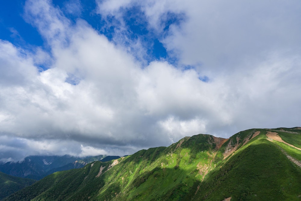 <p>横通岳、大天井岳方面。これがこの四日間で最大の青空。<br>このあとまた天気が崩れていき、再び青空が見えることはなかった。</p>