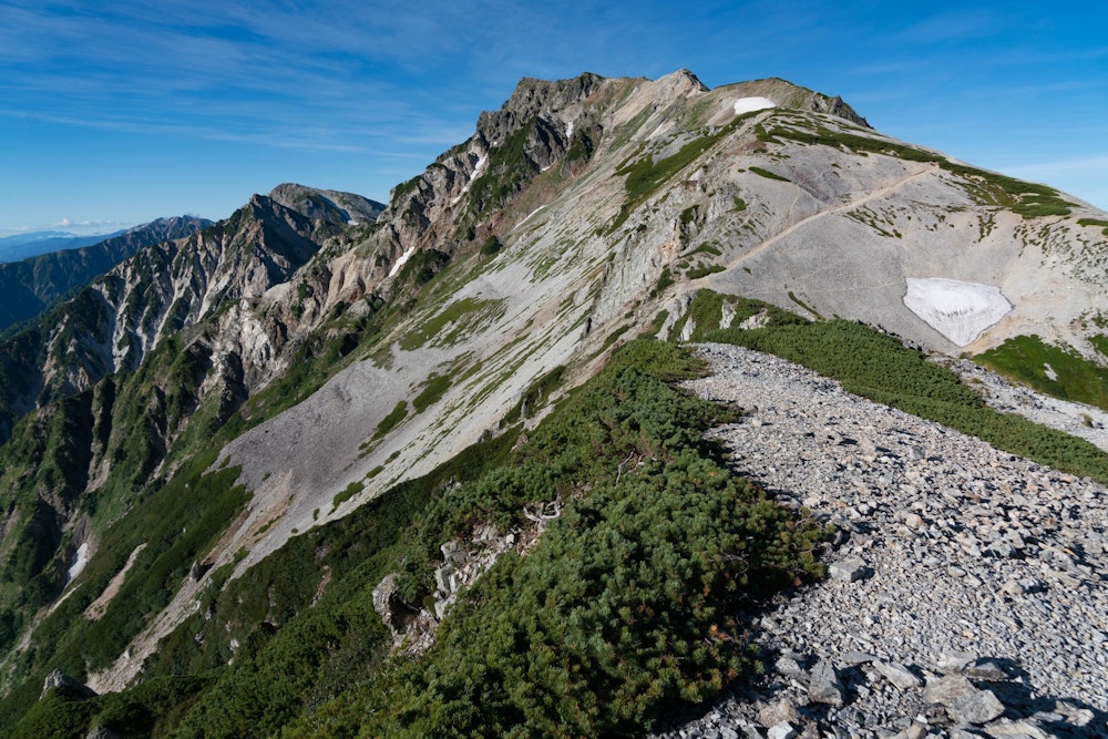 <p>白馬岳を振り返る。<br>空は晴れているが、下山時にはかなり強い風が吹いていた。<br>そして、午後には雲が増え、次第に雨が降ってきた。<br>このまま、当初の計画を死守して雪倉岳に縦走していたら辛い思いをしていただろう。<br>やはり、天気予報をしっかりと確認して行程を組むことは重要。</p>