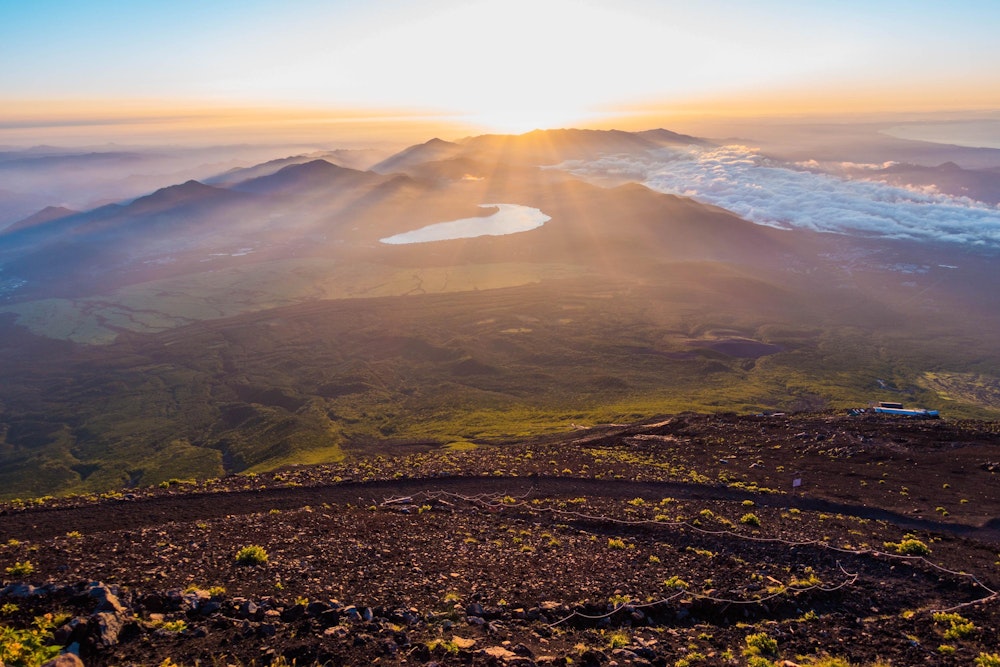 <p>頂上に着く前に、太陽が昇ってきた。<br>辿ってきた登山道が朝日に照らされ浮かび上がる。</p>