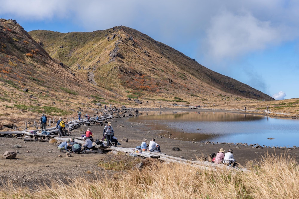 <p>木道に沿って腰をかけ、思い思いの時間を過ごす人たち。</p>