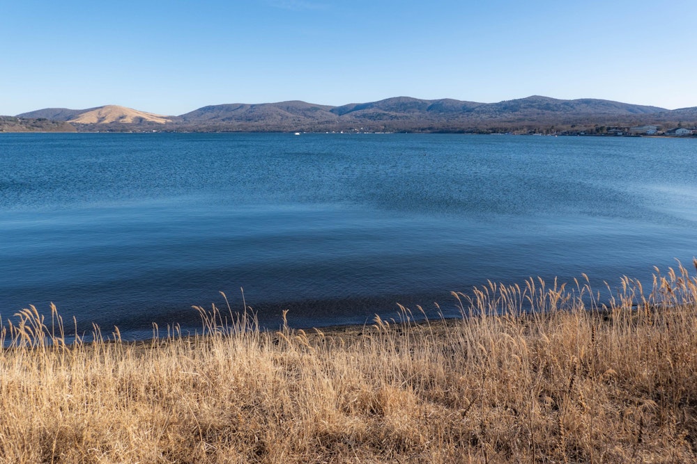 <p>下山し、ちょうど山中湖を一周して戻ってきたところ。<br>奥に見えるなだらかな山々が、今日の後半に歩いた三国山や大洞山など。<br>最高気温は 0 ℃あるかどうかのピリッと冷えた一日だったが、風が穏やかで登山日和だった。</p>