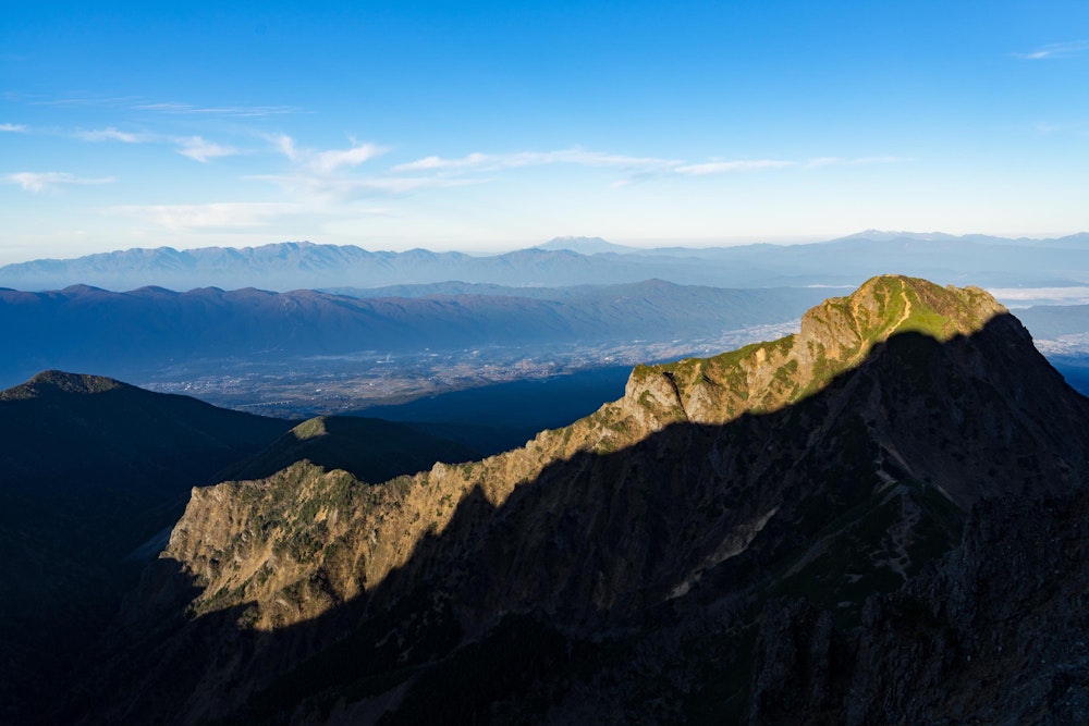 <p>これから目指す阿弥陀岳に、赤岳の影がかかって細く浮かび上がる。</p>