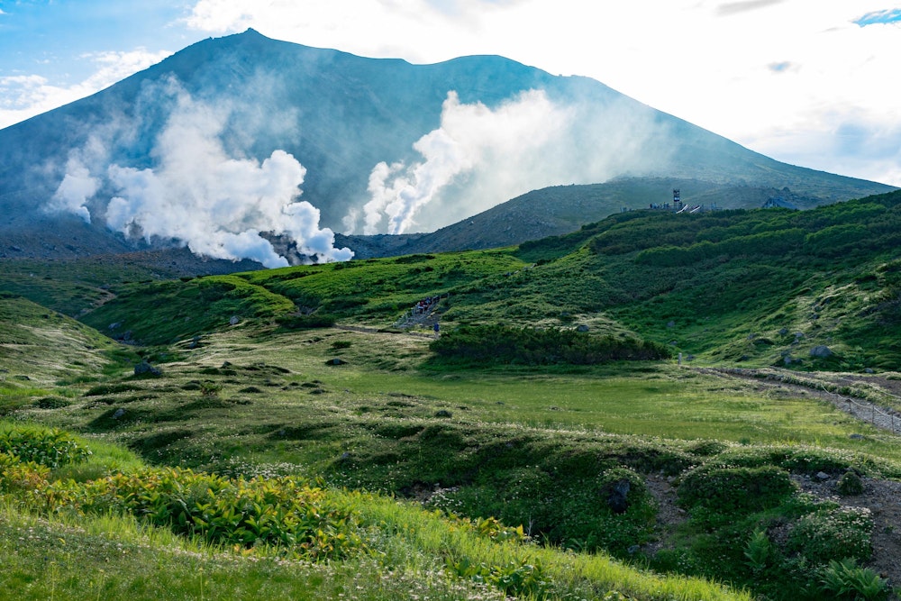 <p>姿見からの旭岳。大雪山は活発な活火山で、そこらじゅうで噴気を上げている。</p>