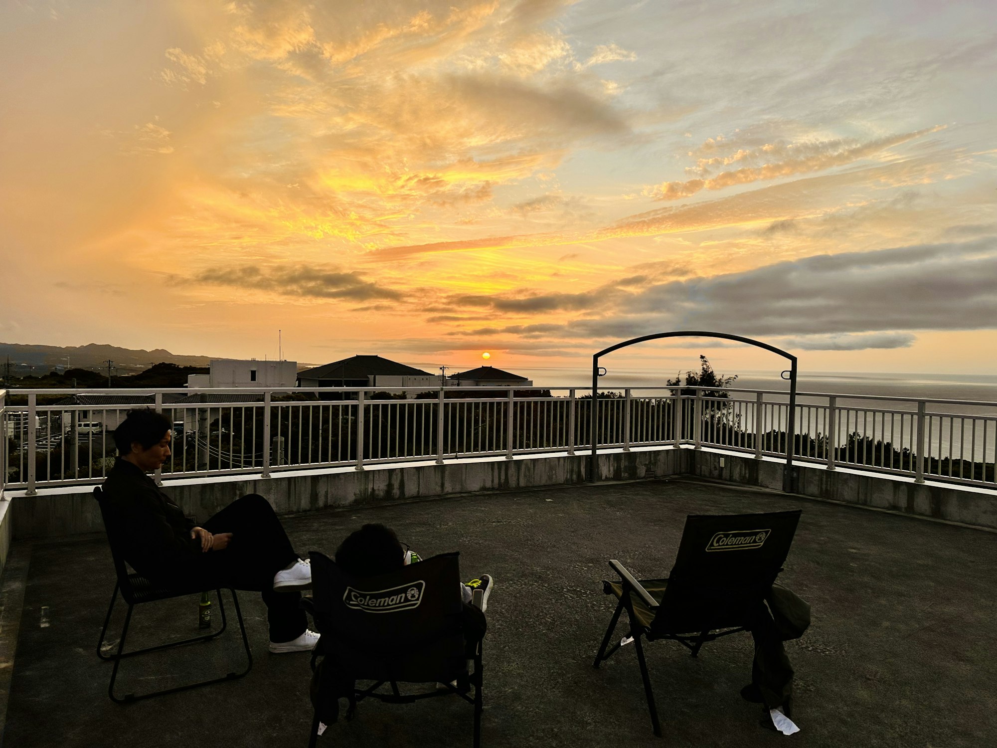 ビールを飲みながら沈む夕日を見るメンバー