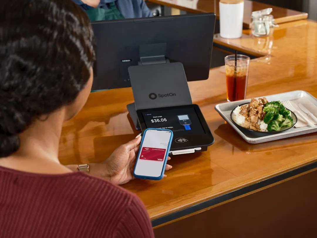 飲食店で顧客がスマートフォンをかざしてキャッシュレス決済を行う様子