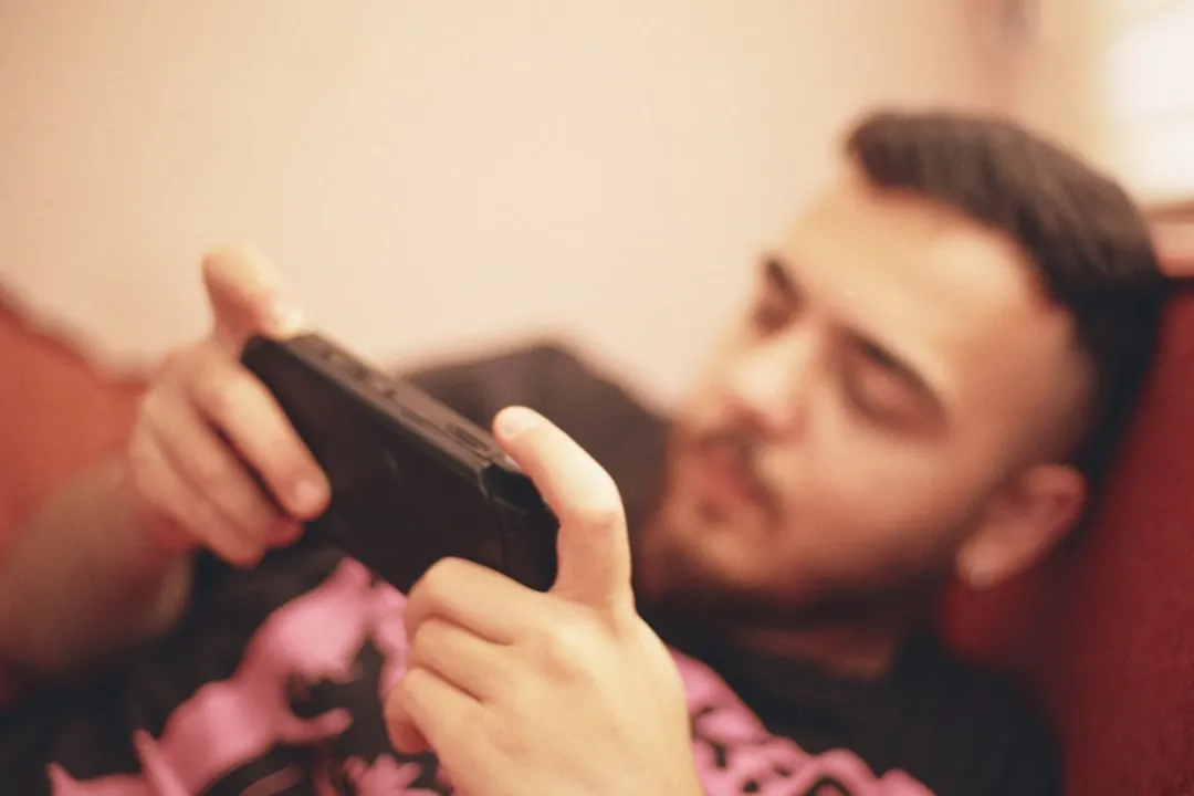 スマートフォンでモバイルゲームをプレイする若者―ゲーム内広告の接触シーン