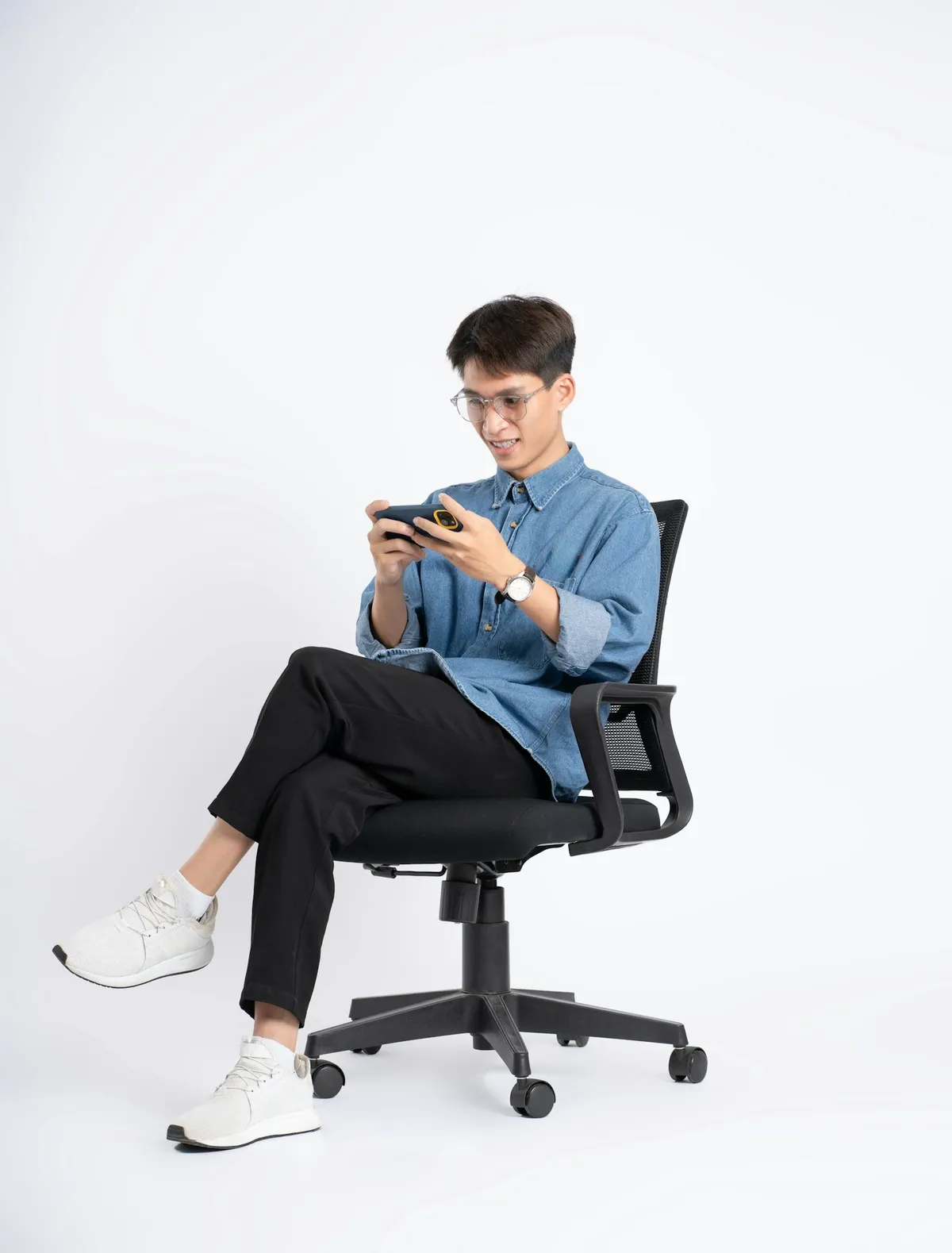 スマートフォンでモバイルゲームに集中するZ世代の若者