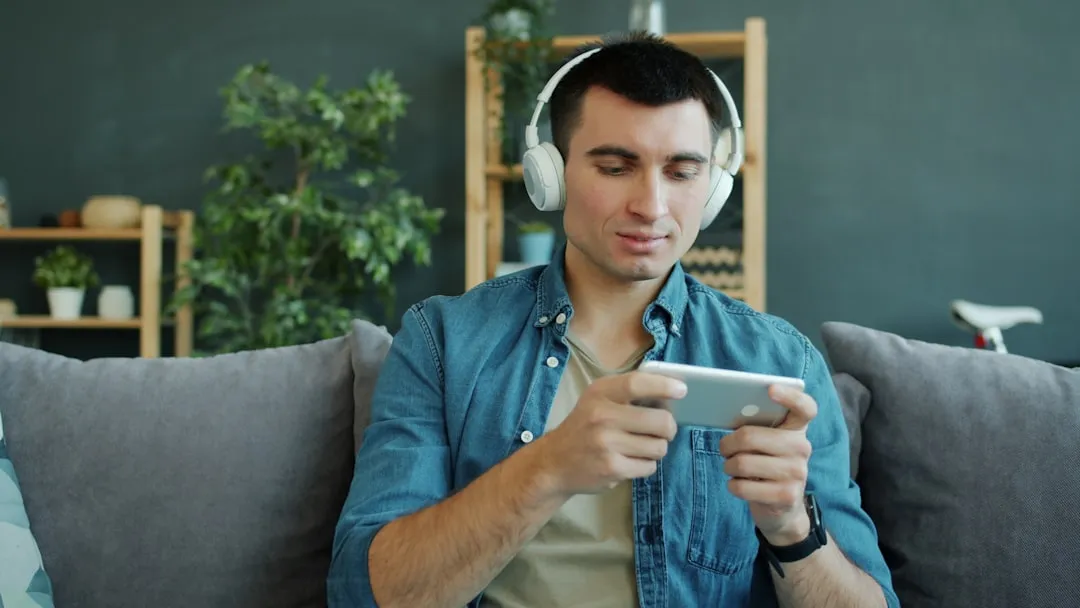 自宅でリラックスしながらスマートフォンゲームをプレイする若年層男性