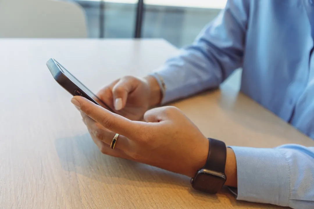 スマートフォンでマーケティングデータを確認するビジネスパーソン。OMO施策の効果測定をデジタルで管理する様子。