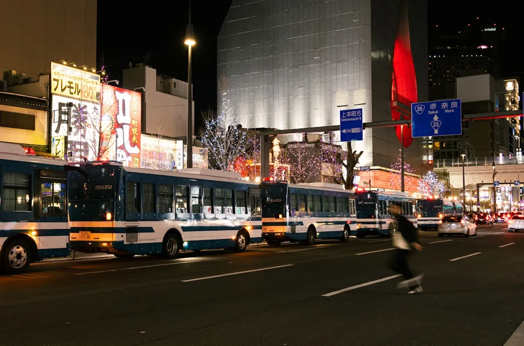 夜の都市を走るバス群 — 交通・インフラ企業が抱えるブランド接触機会の少なさを象徴する都市交通の風景