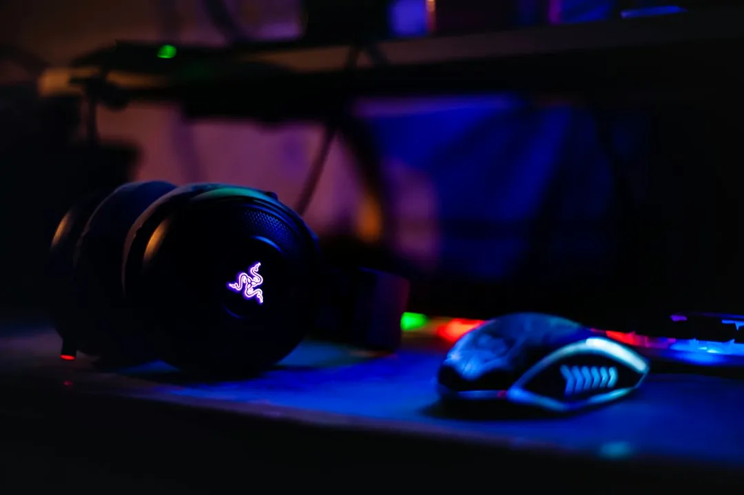 暗い部屋で光るゲーミングヘッドセットとマウス。Discordユーザーの多くが過ごすPCゲーム環境のイメージ