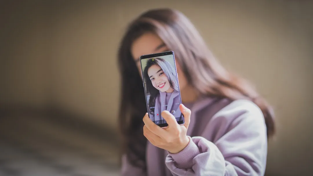 スマートフォンでメイクの自撮りを投稿する若い女性のイメージ