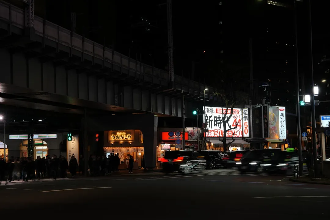 夜の街に並ぶ大型LEDビジョン広告と3D OOH屋外広告の活用例」 width=