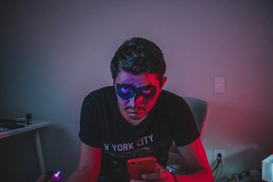 スマートフォンでモバイルゲームをプレイする若者。SNSが届かないゲーム中の時間帯に広告接点を作れる