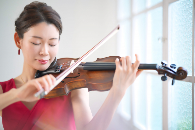 ヴァイオリンを弾く赤い服を着た女性