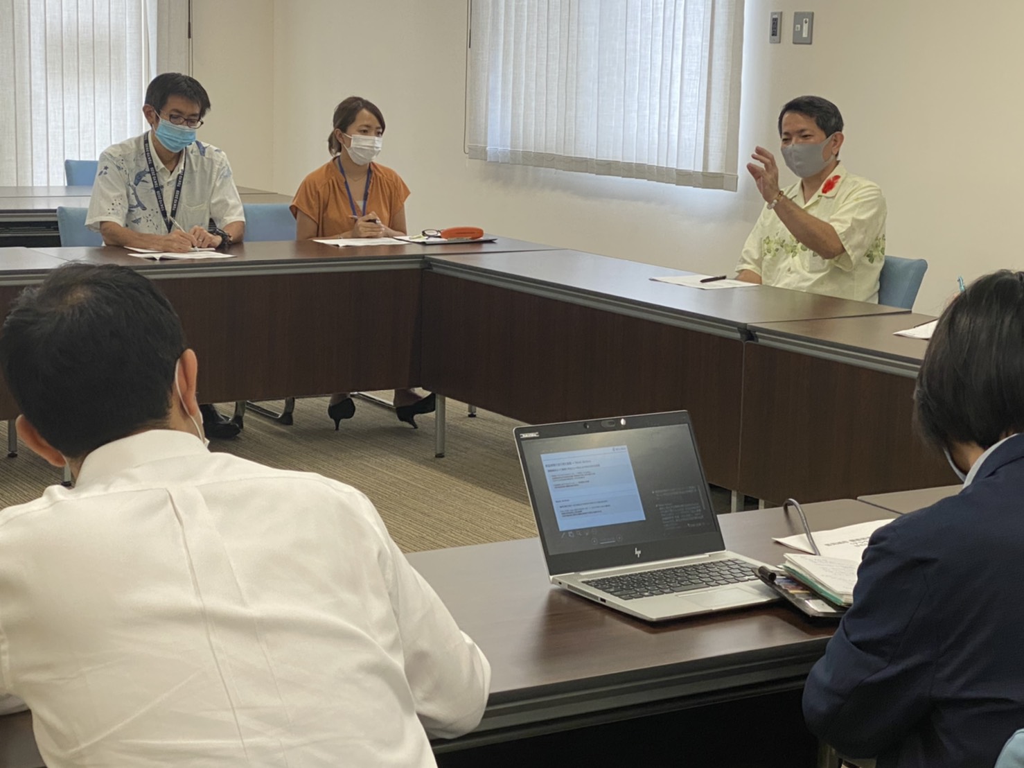 豊見城市の防災に関する課題を挙げながら、政策方針を説明する山川仁市長（右奥）＝10月8日、豊見城市役所