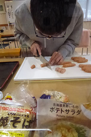 A student cutting sausages