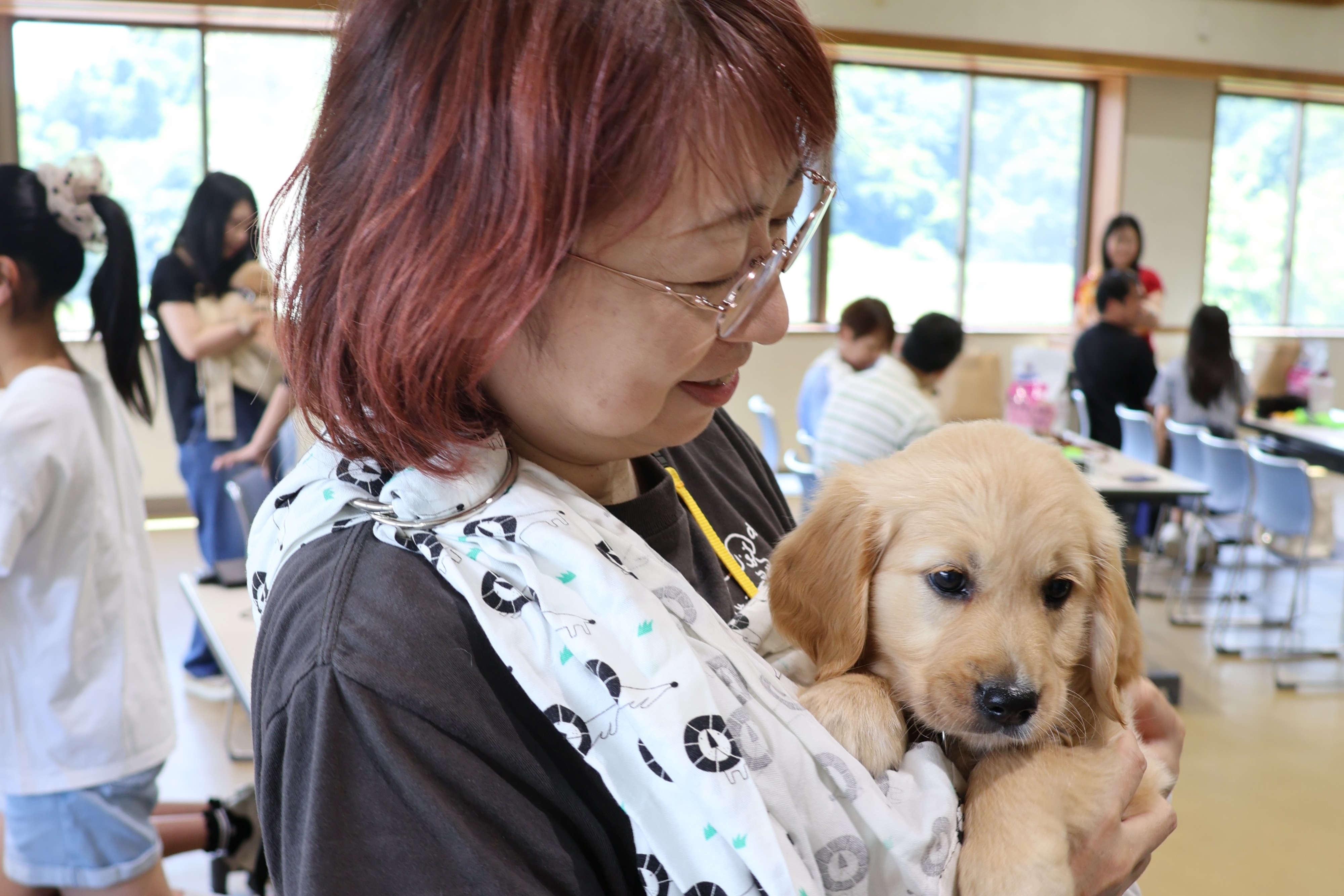 A woman holding a puppy in her arms and smiling gently