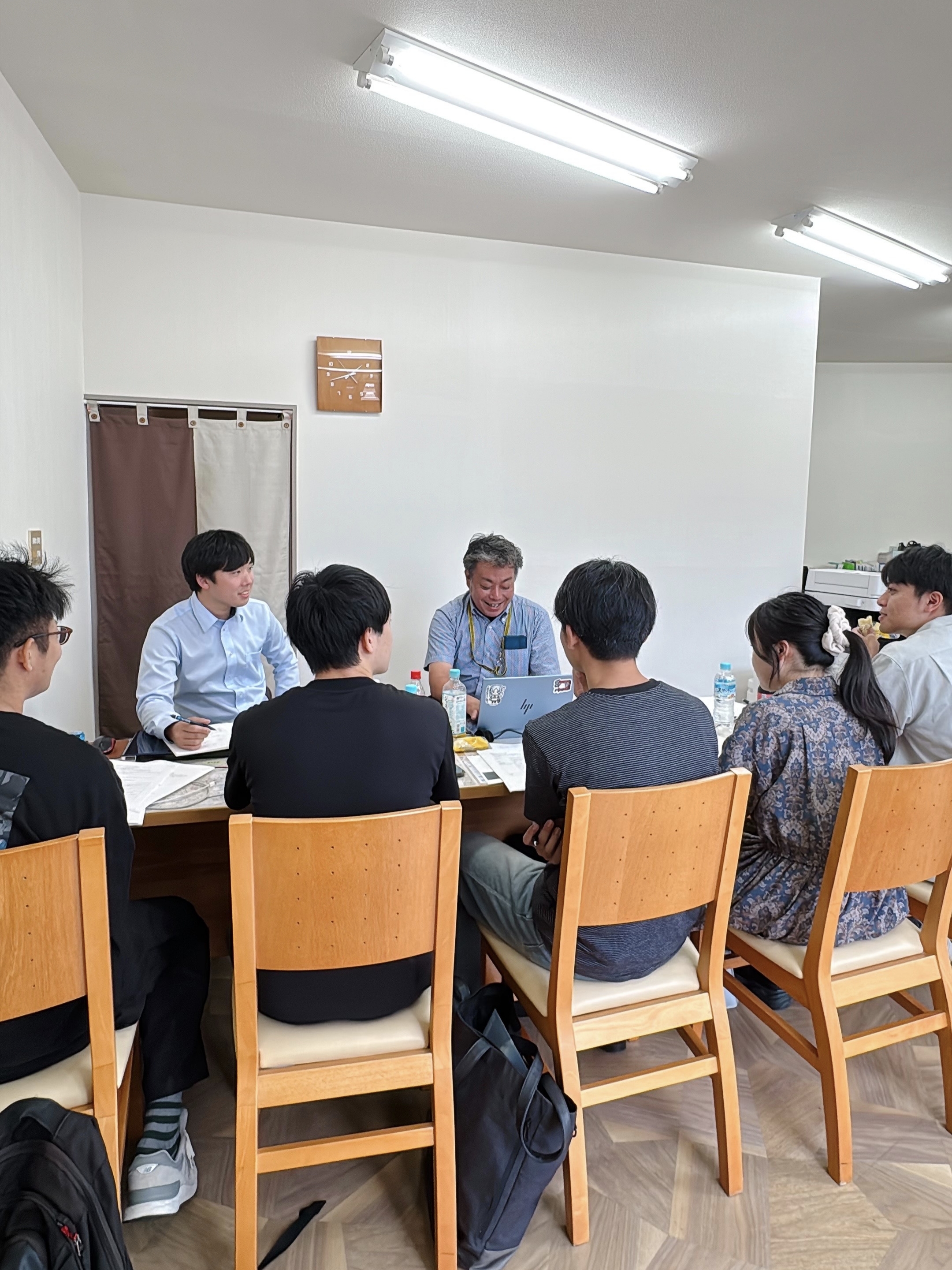 学生と企業の担当者がテーブルを囲み交流するイメージ