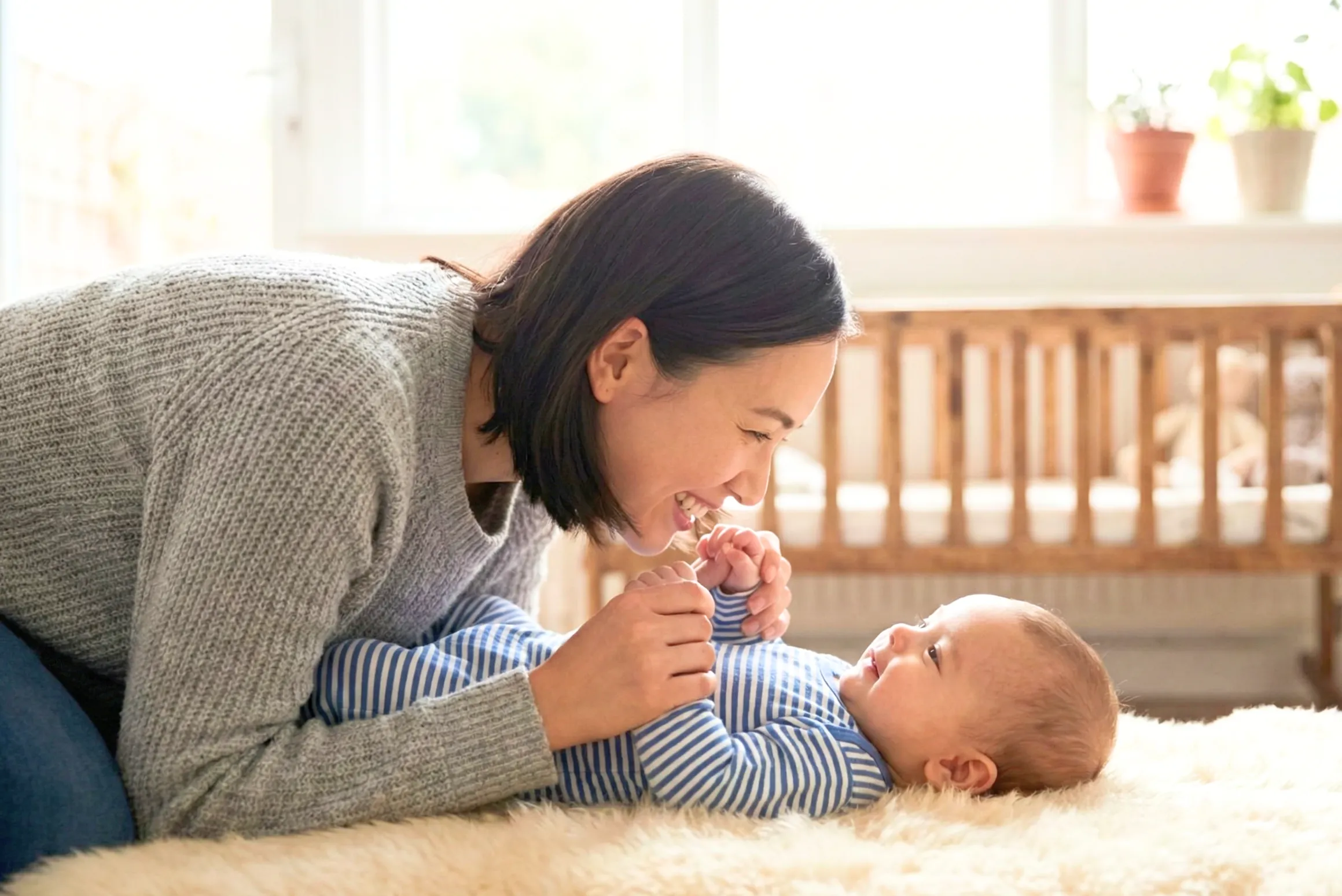 赤ちゃんとママが笑顔で見つめている光景