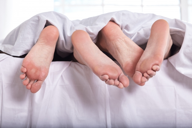 ベッドの中のカップルの足の裏