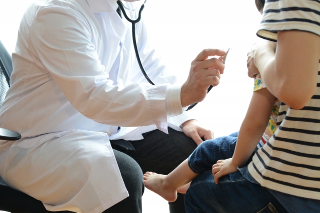 聴診器を子どもに当てる医師