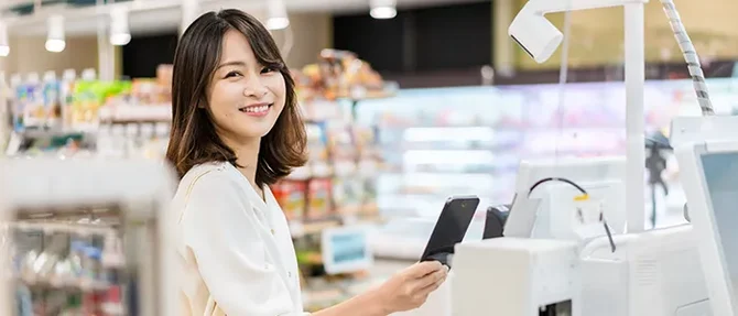 レジでスマホを使う女性