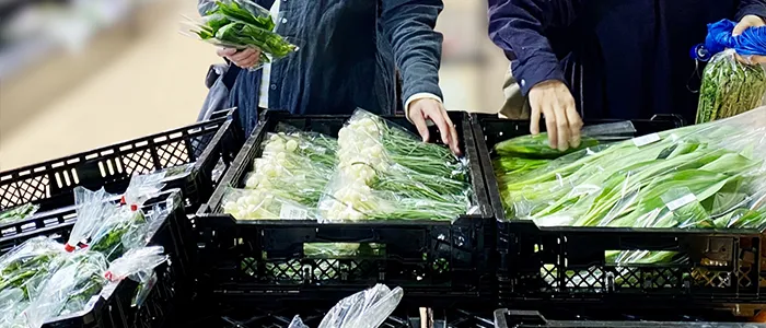 お店で野菜を買う人々