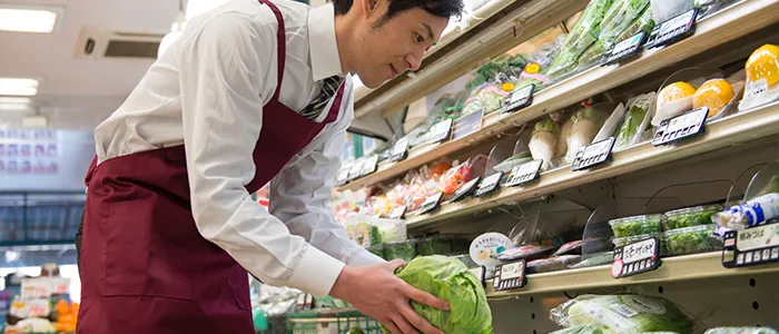 商品を陳列するスーパーマーケットの店員