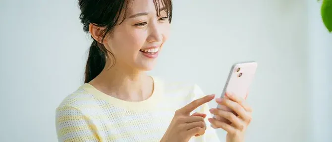 スマホを操作する笑顔の女性