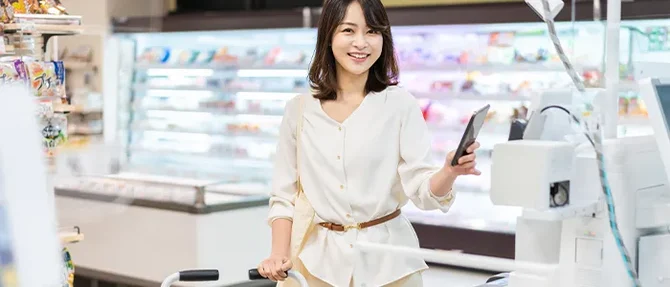 レジでスマホを使う女性