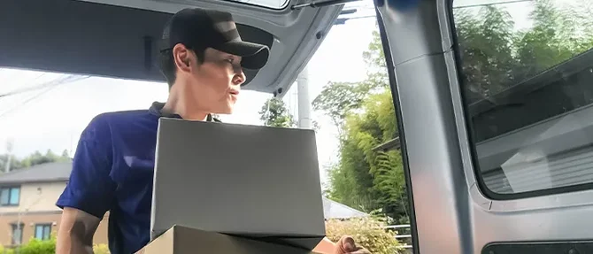 トラックに荷物を積むドライバー