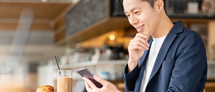 カフェでSNSを見る男性