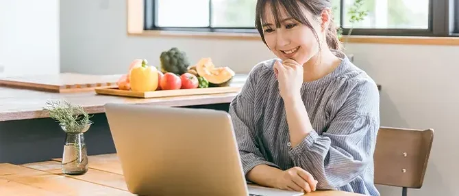 料理についてパソコンで調べる主婦