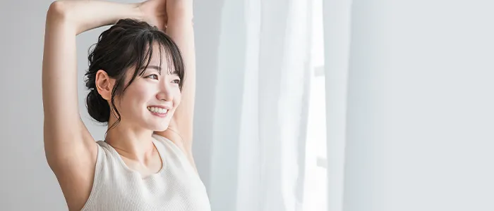 窓際でストレッチを行う女性