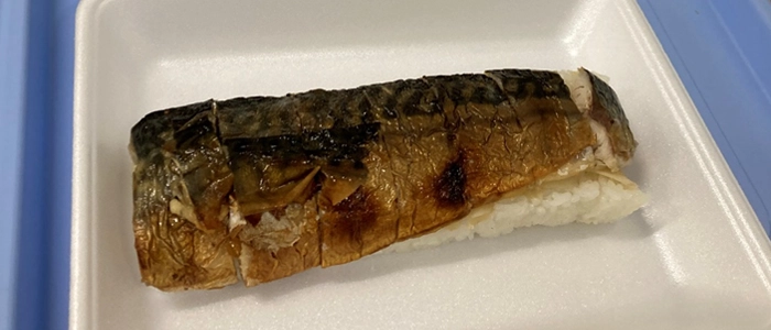 鯖の押し寿司をトレーにのせている様子