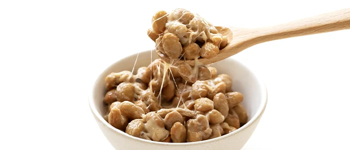 お皿に盛られた納豆とスプーンで掬われた納豆