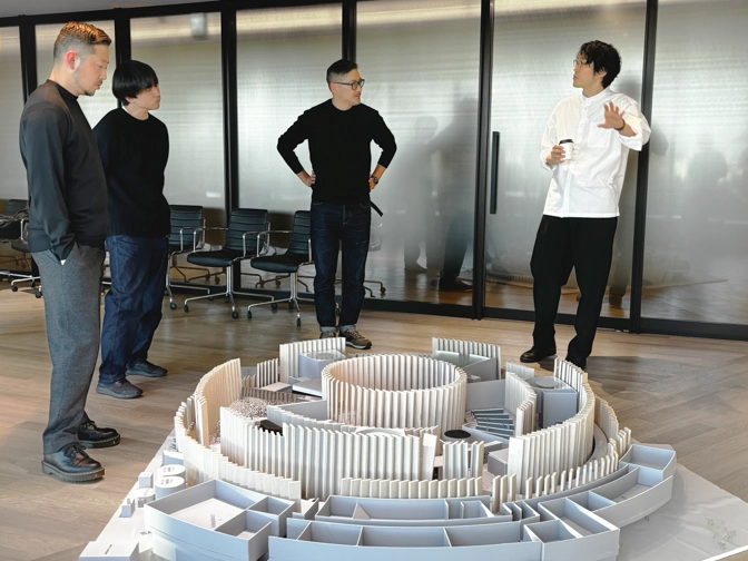 Photo capturing a discussion around a model of the pavilion