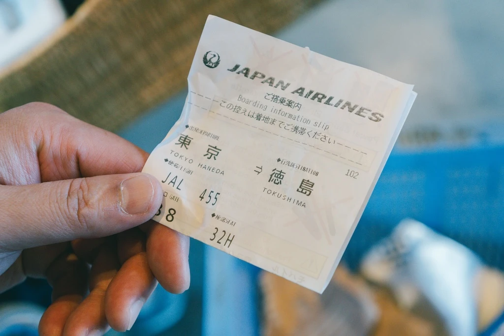 Photo of the hand holding the boarding pass.