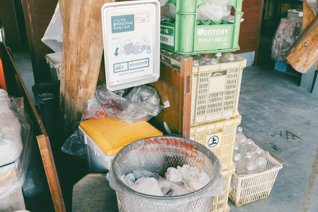 This is a picture of one of the trash stations. Above the “must-burn” trash cans is a sign that reads “out” and “61.