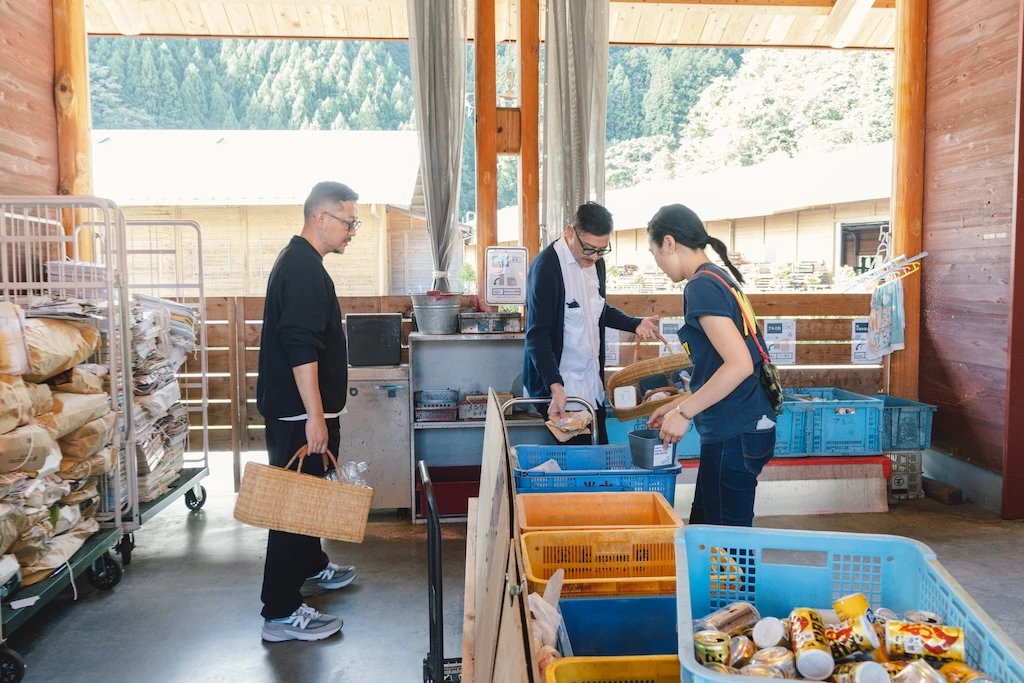 Mr. Irobe, Mr. Watanabe, and Ms. Otsuka look around at the various types of trash collected at the trash station.