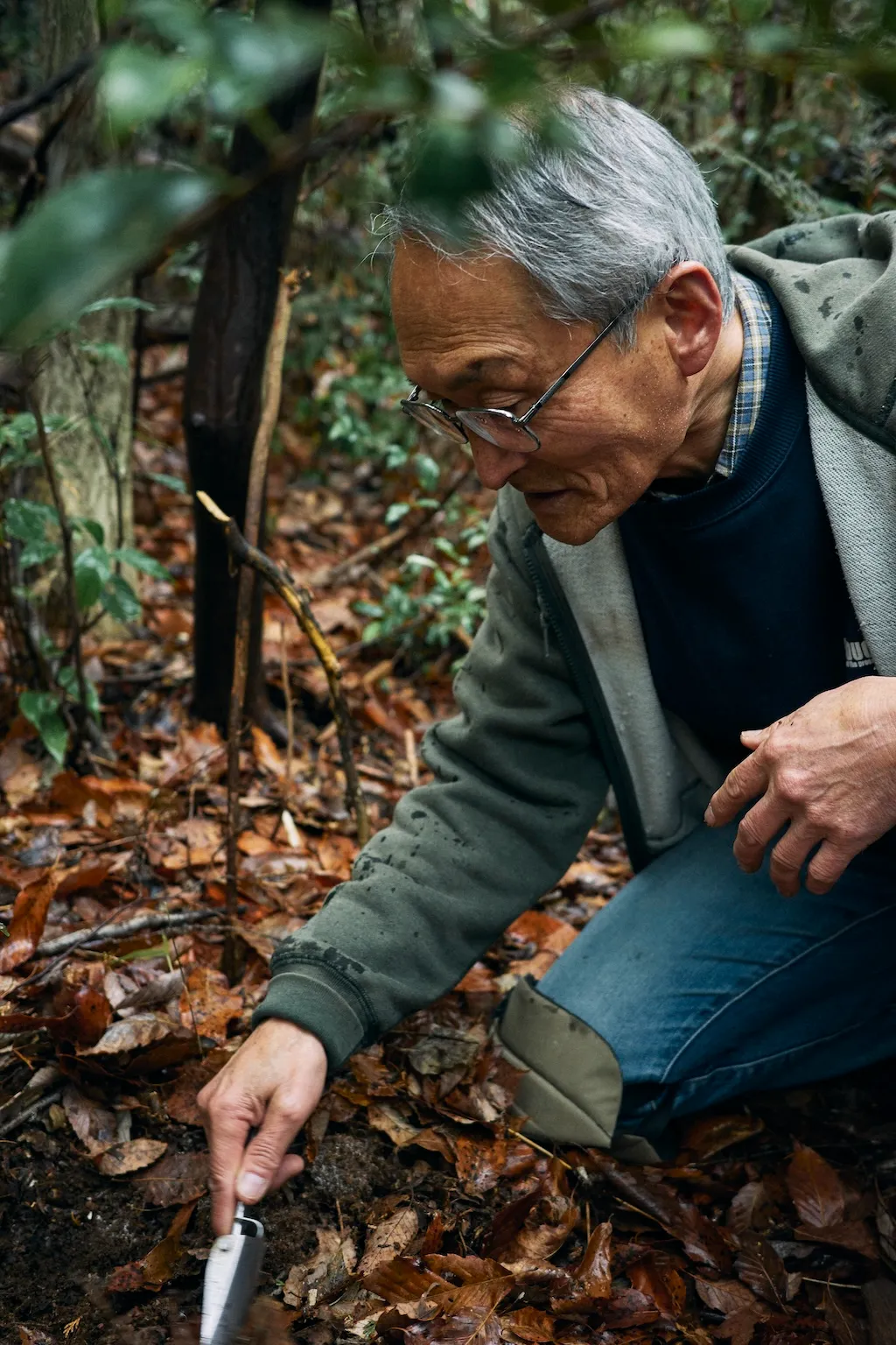 Mr.Izawa digging up the soil in the forest.