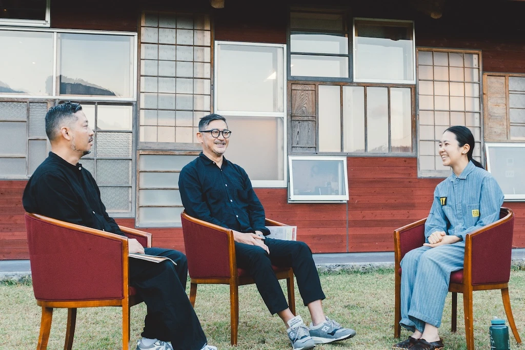 A photo of Mr. Irobe, Mr. Watanabe, and Ms. Otsuka sitting in chairs facing each other and chatting.