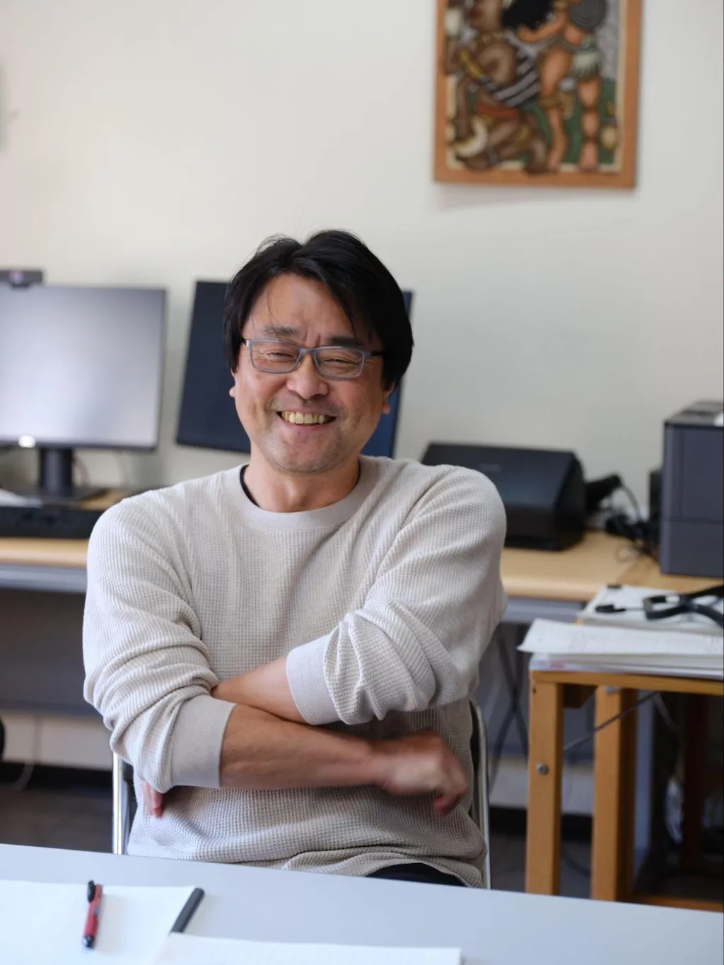 Photo of Professor Umezaki speaking in his lab, his arms crossed.